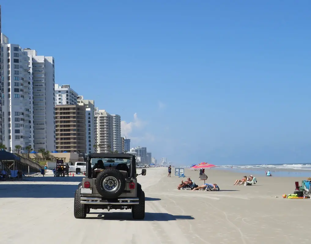 Jeep drives on Daytona Beach by condos