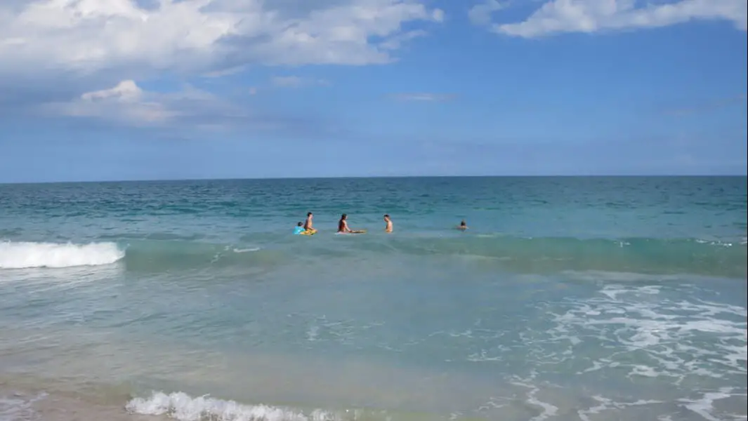People swim in ocean at Vero Beach, FL